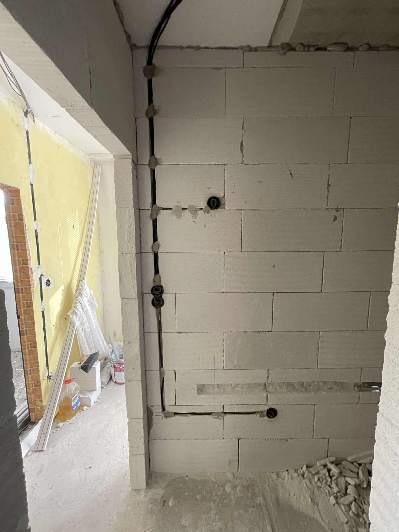 Nová elektroinstalace ve zdi z tvárnic během rekonstrukce pokoje.