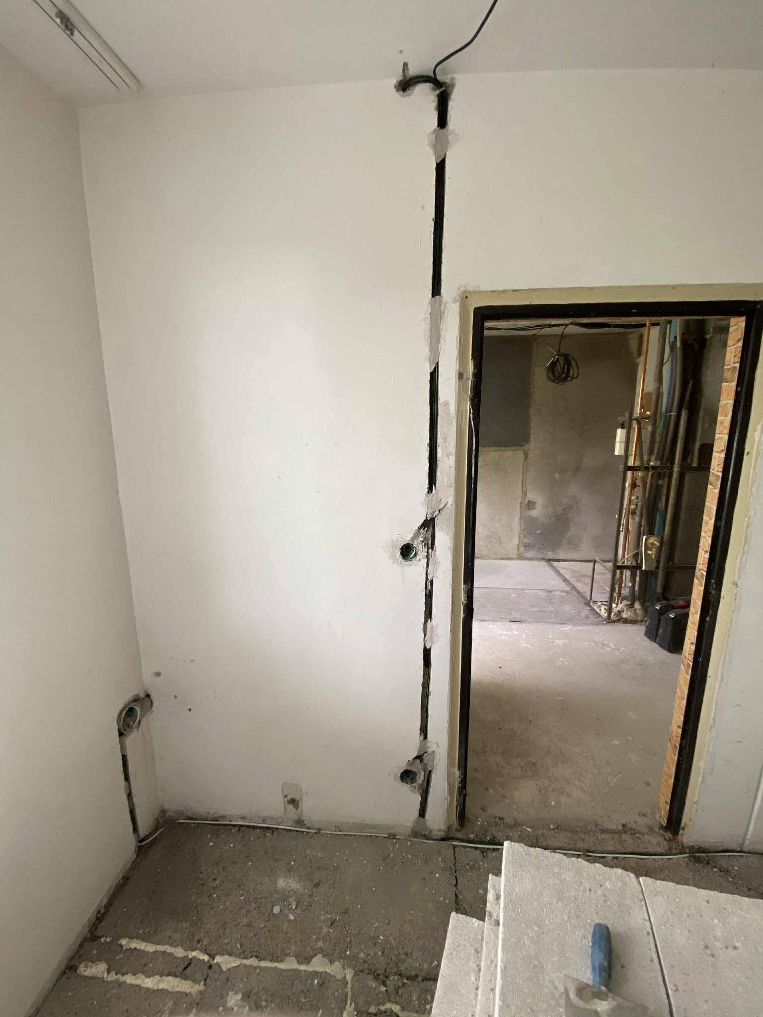 Nové rozvody elektřiny zasekané ve zdi vedle dveří.